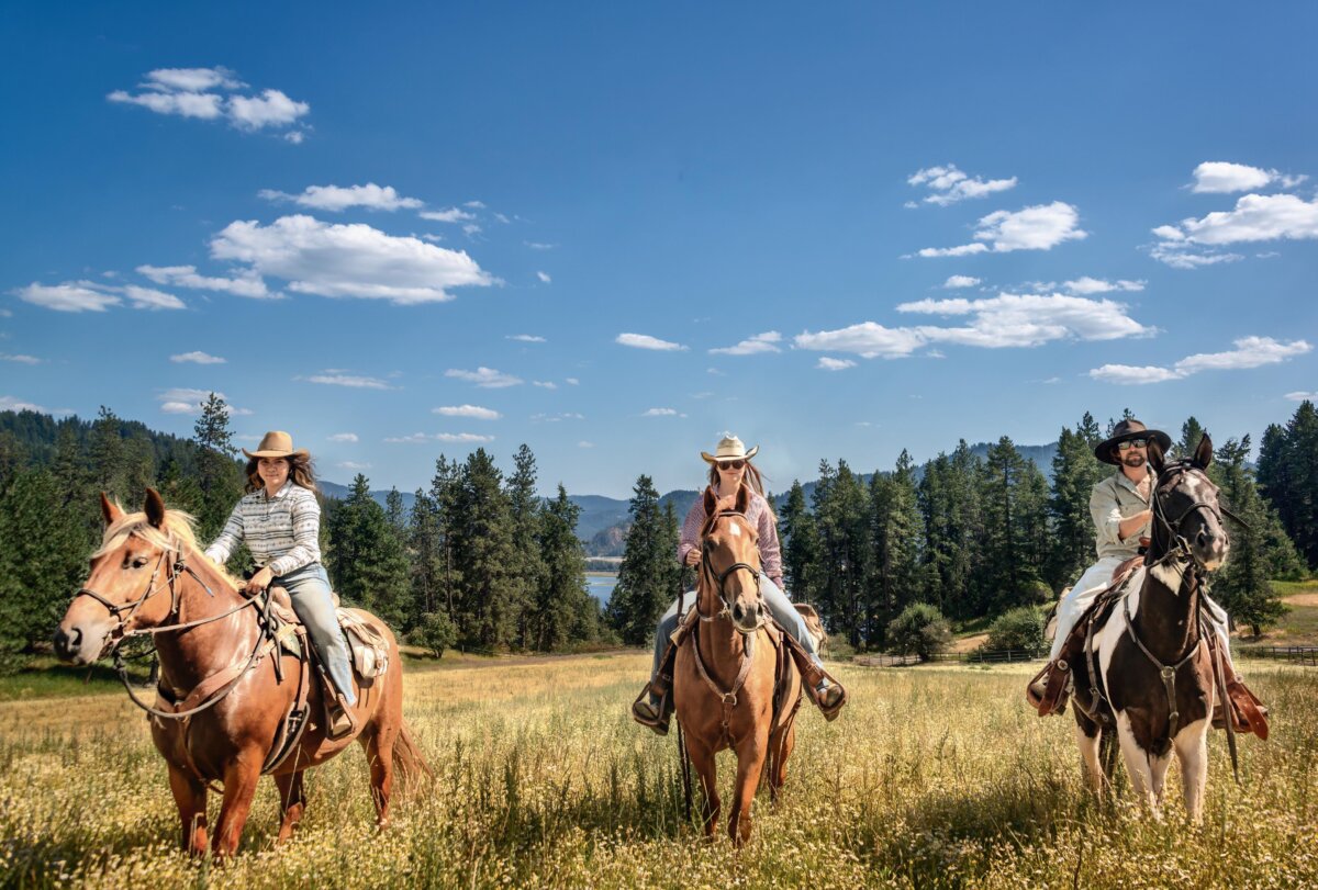 Wranglers (L to R) Indigo Boggs, Julianna Hopper, and Jonah Collier ride on the meadow at Red Horse Mountain Ranch in Idaho. (Maria Coulson)