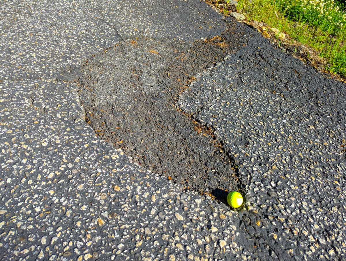 This asphalt patch was installed two years ago. It was a product in a bag bought from a home center. It started to fail within one year. The golf ball is for scale. (Tim Carter/Tribune Content Agency/TNS)
