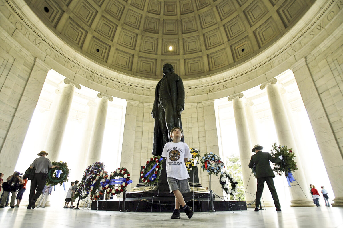 Park Rangers set wreaths of flowers inside the Jefferson Memorial as a boy reads inscriptions of Thomas Jefferson's speeches and writings, in Washington, in this file photo. (Chip Somodevilla/Getty Images)