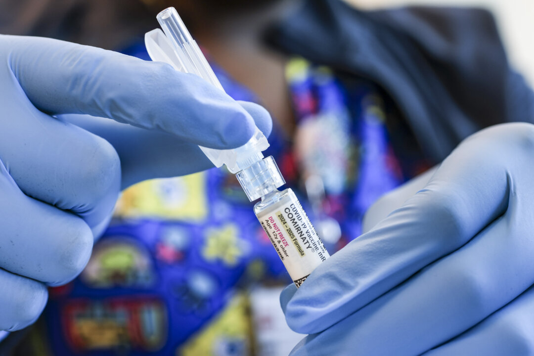 MIAMI, FLORIDA - MAY 29: In this photo illustration, Ruth Jones, Immunization Nurse, holds a Pfizer-BioNTech COVID-19 vaccine (brand name: Comirnaty) at Borinquen Health Care Center on May 29, 2025 in Miami, Florida. Health Secretary Robert F. Kennedy Jr. announced that he will no longer recommend that healthy children and pregnant people get COVID-19 shots. (Photo illustration by Joe Raedle/Getty Images)