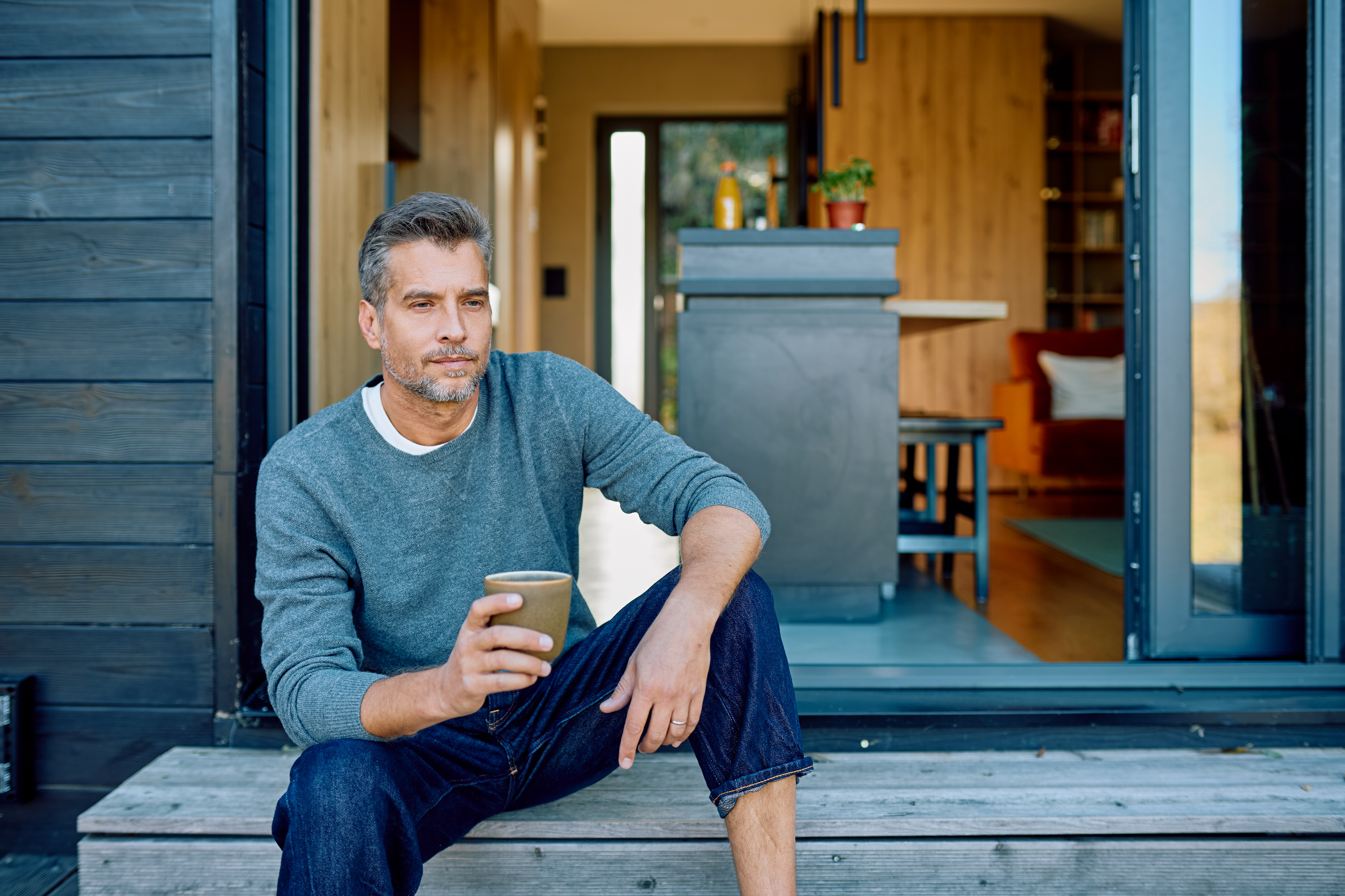 Thoughtful,Man,Sitting,On,Porch,Steps,,Drinking,Coffee,,Relaxing,In