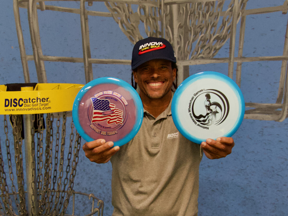 Chris Brophy, professional disc golfer and Innova's project manager, displays the company's "Support Our Troops" and "National Veterans Wheelchair Games" discs in the factory outlet store in Rancho Cucamonga, Calif. on June 3, 2026. (Travis Gillmore/The Epoch Times)