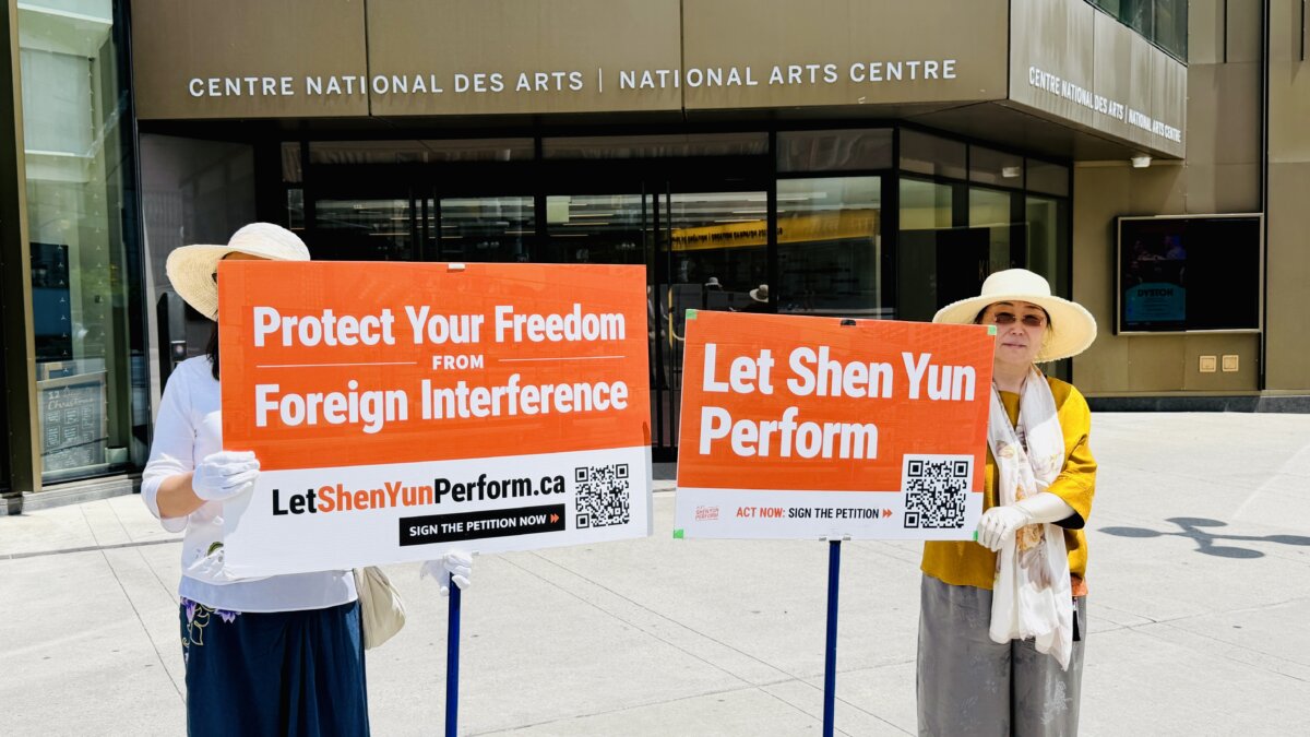 Fans of Shen Yun Performing Arts hold signs in support of the classical Chinese dance company, standing outside the National Arts Centre in Ottawa on June 17, 2026. (The Epoch Times)
