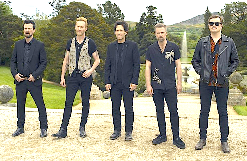 5 men stand in a gravel patch in Power Ballad