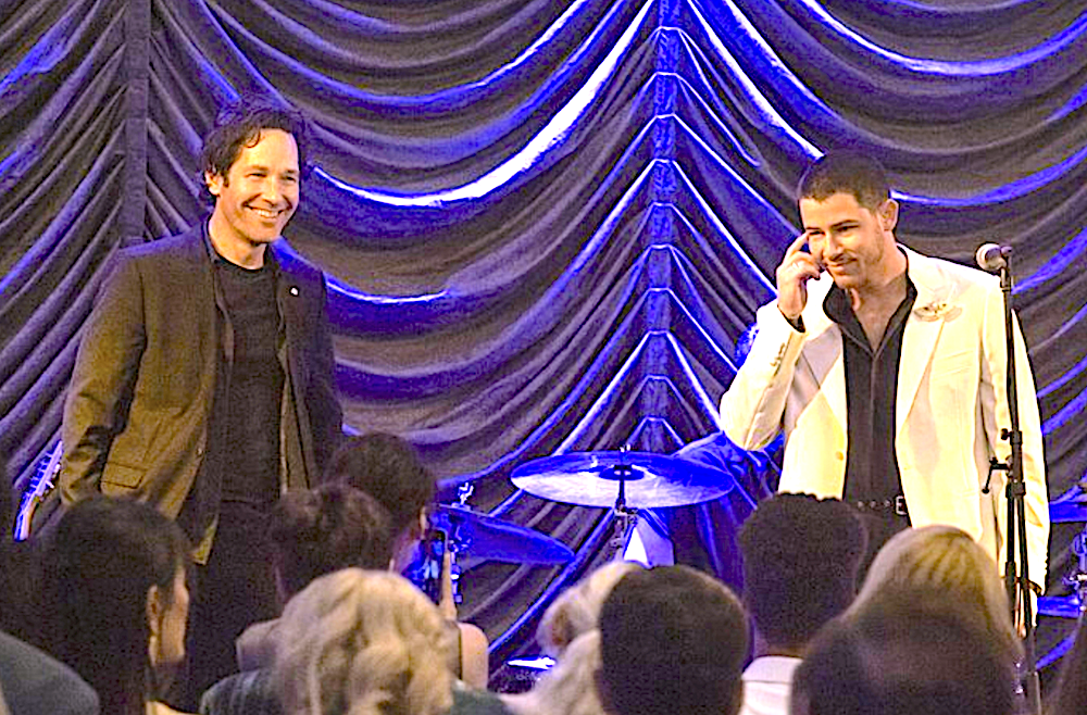man in black and man in white on stage with purple curtain in Power Ballad