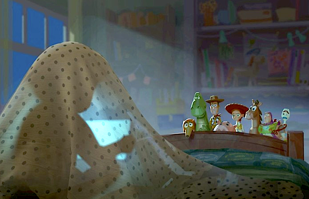 Young girl on her tablet under the covers, being observed by a toy collection at the foot of her bed in Toy Story 5