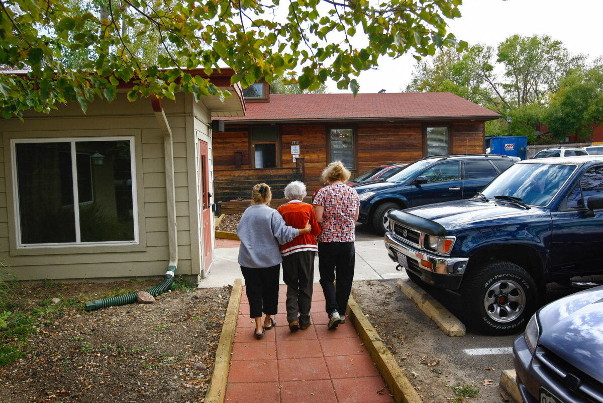 Volunteers assist a terminally ill patient at a hospice in Denver in a file photo. (John Moore/Getty Images)