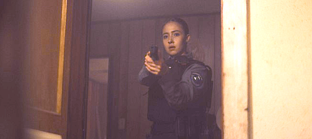Young female police officer points weapon in Gangland