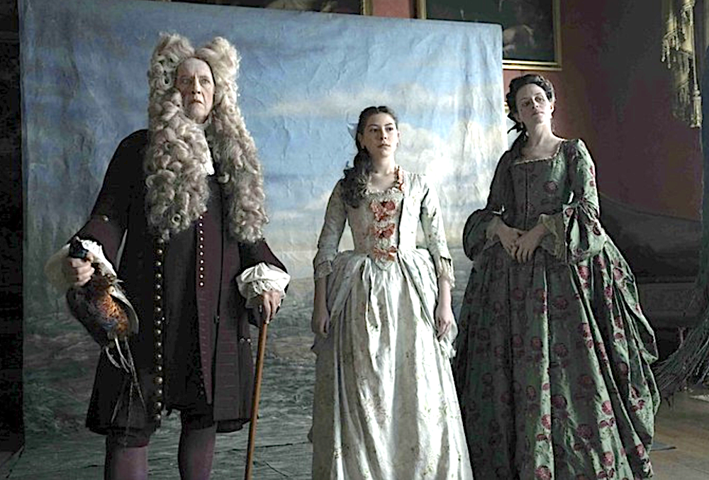 one man and two women stand in front of painted backdrop in Savage House