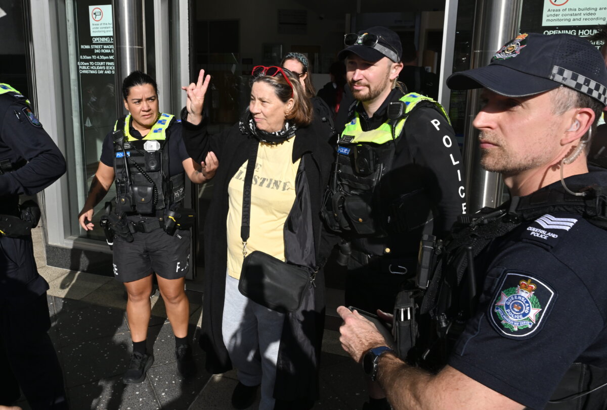 Activist Helen O’Sullivan (centre) is seen being detained by police at Brisbane Magistrates Court in Brisbane, Australia, on June 30, 2026, (AAP Image/Darren England)