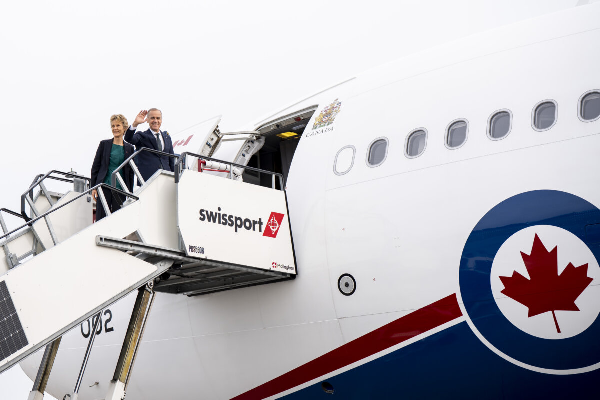 Prime Minister Mark Carney and Diana Fox Carney board a government airplane in Dublin, on June 14, 2026. (The Canadian Press/Christopher Katsarov)
