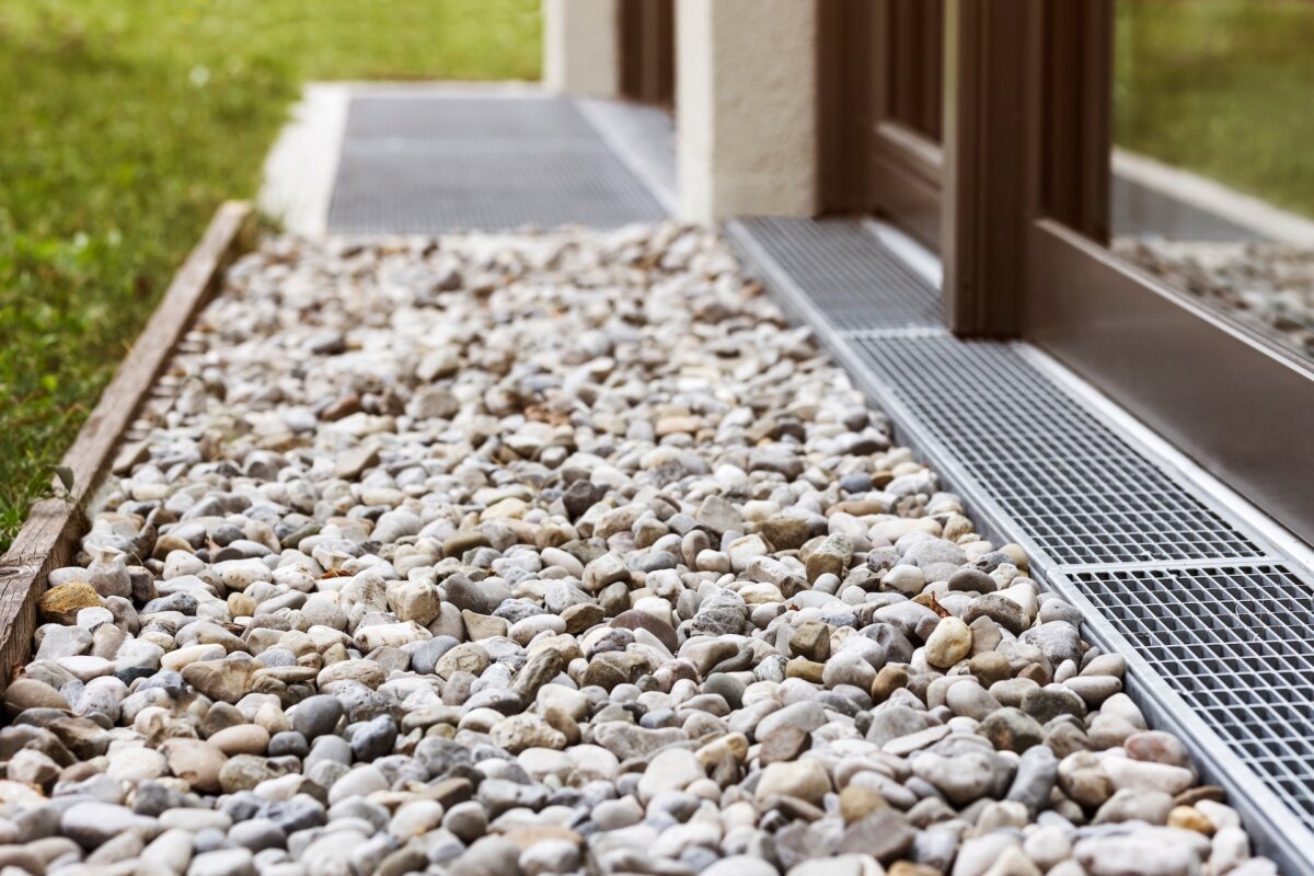 A French drain is a gravel-filled trench that contains a perforated pipe that redirects surface and groundwater away from vulnerable areas. (Mariana Serdynska/Shutterstock)