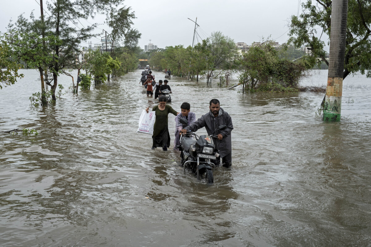 Residents walk through a street flooded due to heavy rains in Vasai, India, on July 8, 2026. (Punit Paranjpe/AFP via Getty Images)