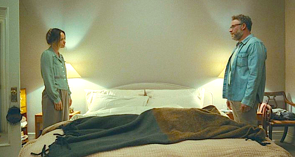 man and woman face each other across a bed in The Invite