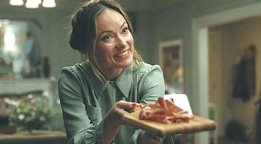 Woman offering charcuterie board to dinner guests in The Invite