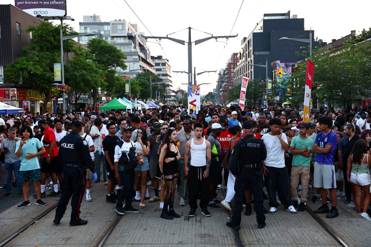 Toronto Police hold back crowds as they respond to an active shooter at the Salsa on St. Clair event in Toronto, on July 11, 2026. (The Canadian Press/Keito Newman)