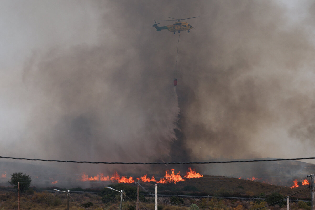 A firefighting helicopter dumps water amid deadly wildfires affecting Almeria province, in Los Gallardos, Almeria, Spain, July 10, 2026. (Violeta Santos Moura/Reuters)