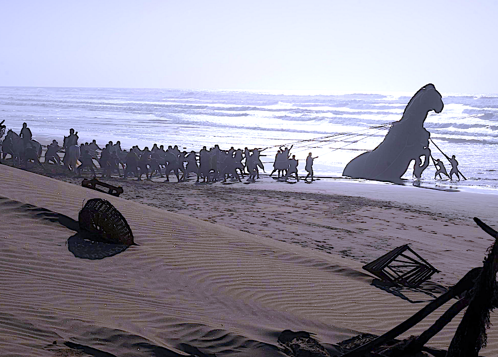 giant wooden horse being pulled on the beach in The Odyssey
