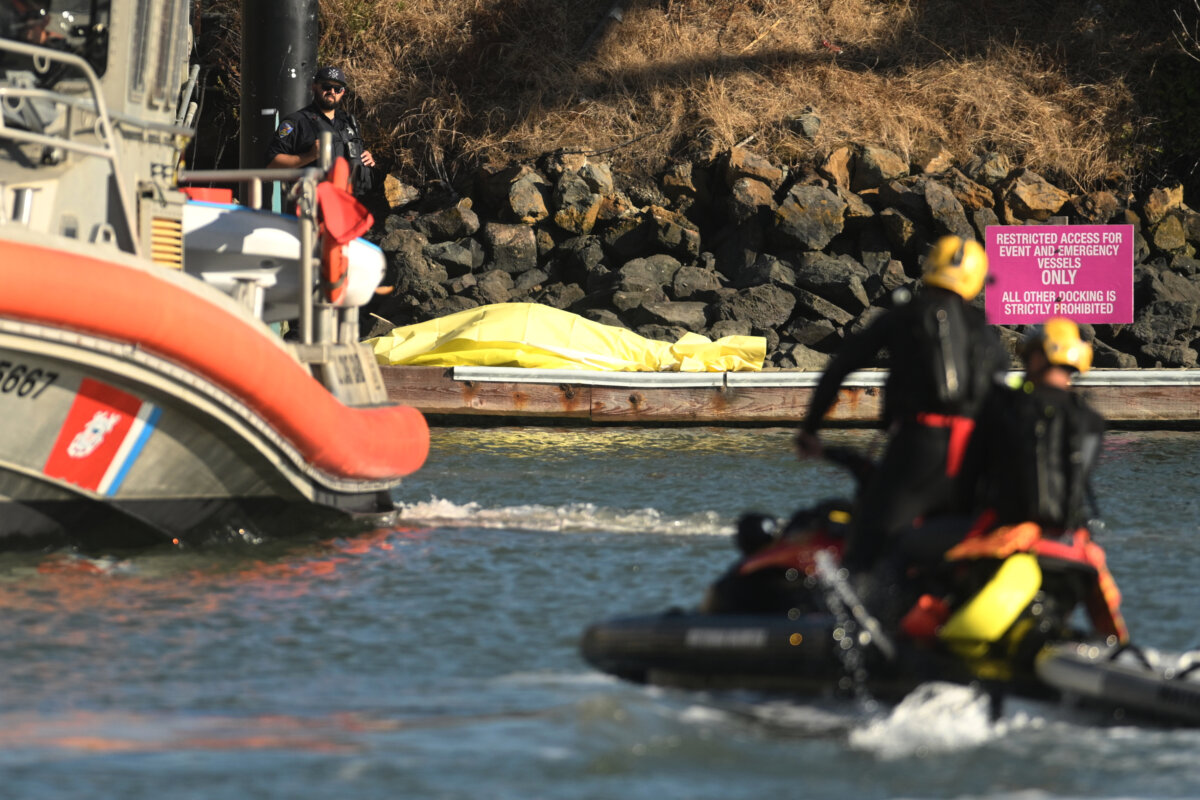 A body is covered with a tarp on a dock near the site of boat accident in San Francisco on July 14, 2026. (Noah Berger/AP Photo)