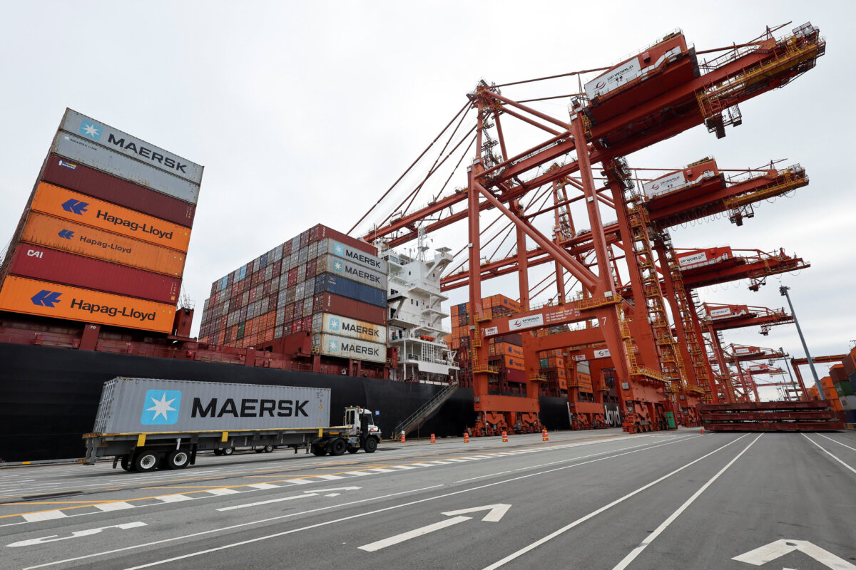 A truck carries a container near a cargo ship at the Port of Vancouver on Aug. 3, 2025. (Chris Helgren/Reuters)