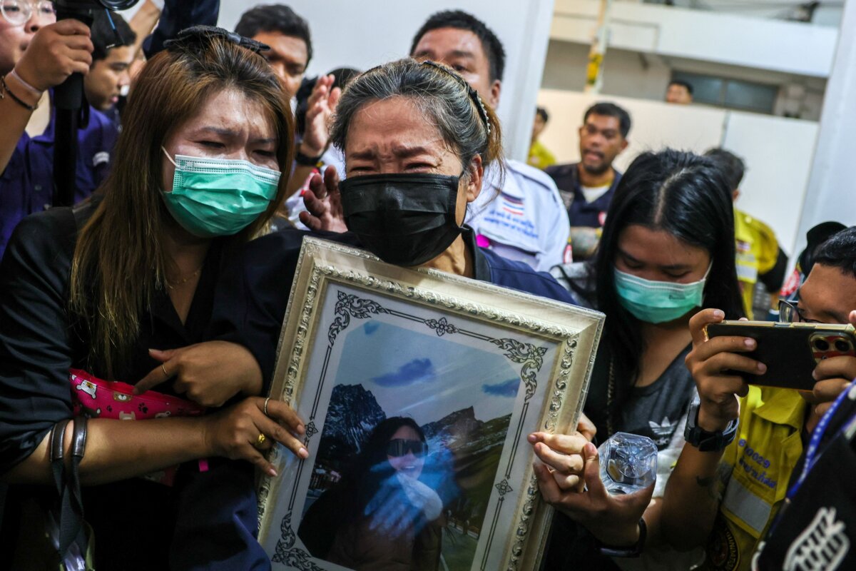 Family members react as they receive the body of a victim at the Police Hospital morgue, following a deadly fire at a pub in Bangkok on July 14, 2026. (Athit Perawongmetha/Rueters)