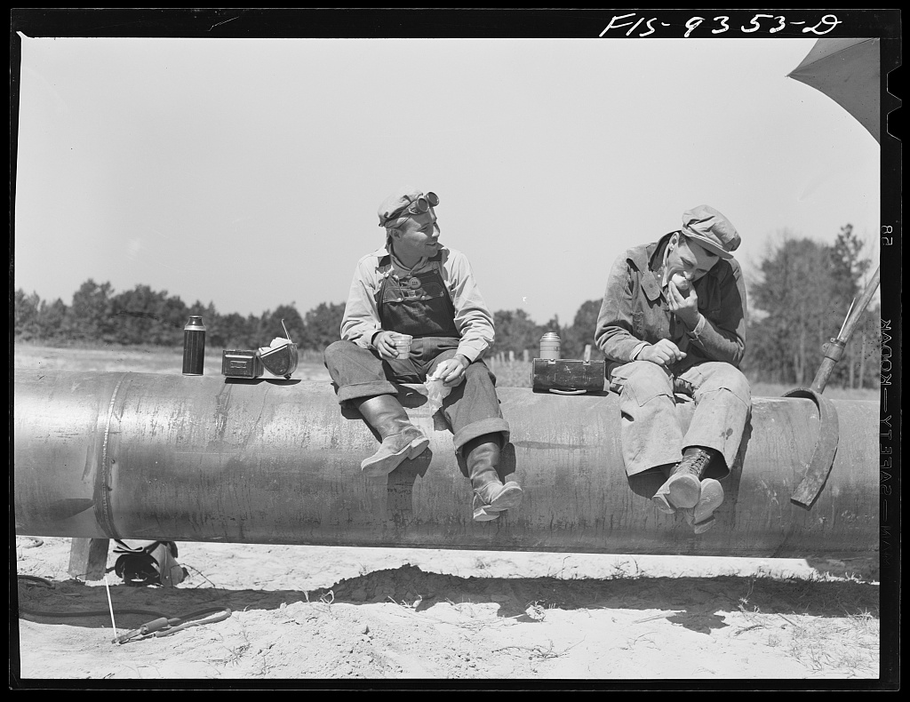 Pipeliners atop the Longview, Texas to Arkansas state line pipeline. This war emergency pipeline would extend to Norris City, Ill. Library of Congress. (Public Domain)