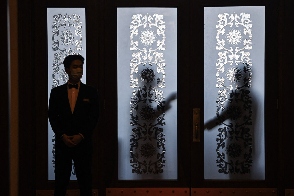 Security guards stand behind a glass door at the Great Hall of the People during the 14th National People's Congress (NPC) in Beijing on March 6, 2024. (Photo by Greg Baker/AFP via Getty Images)