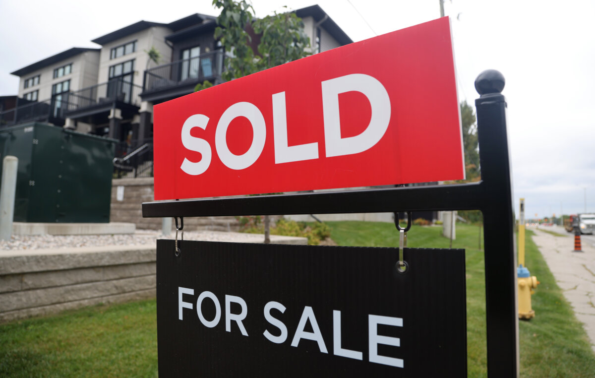 A real estate sign stands in front of residential homes in the Riverside South neighbourhood of Ottawa on Aug. 30, 2024. (The Canadian Press/Patrick Doyle)