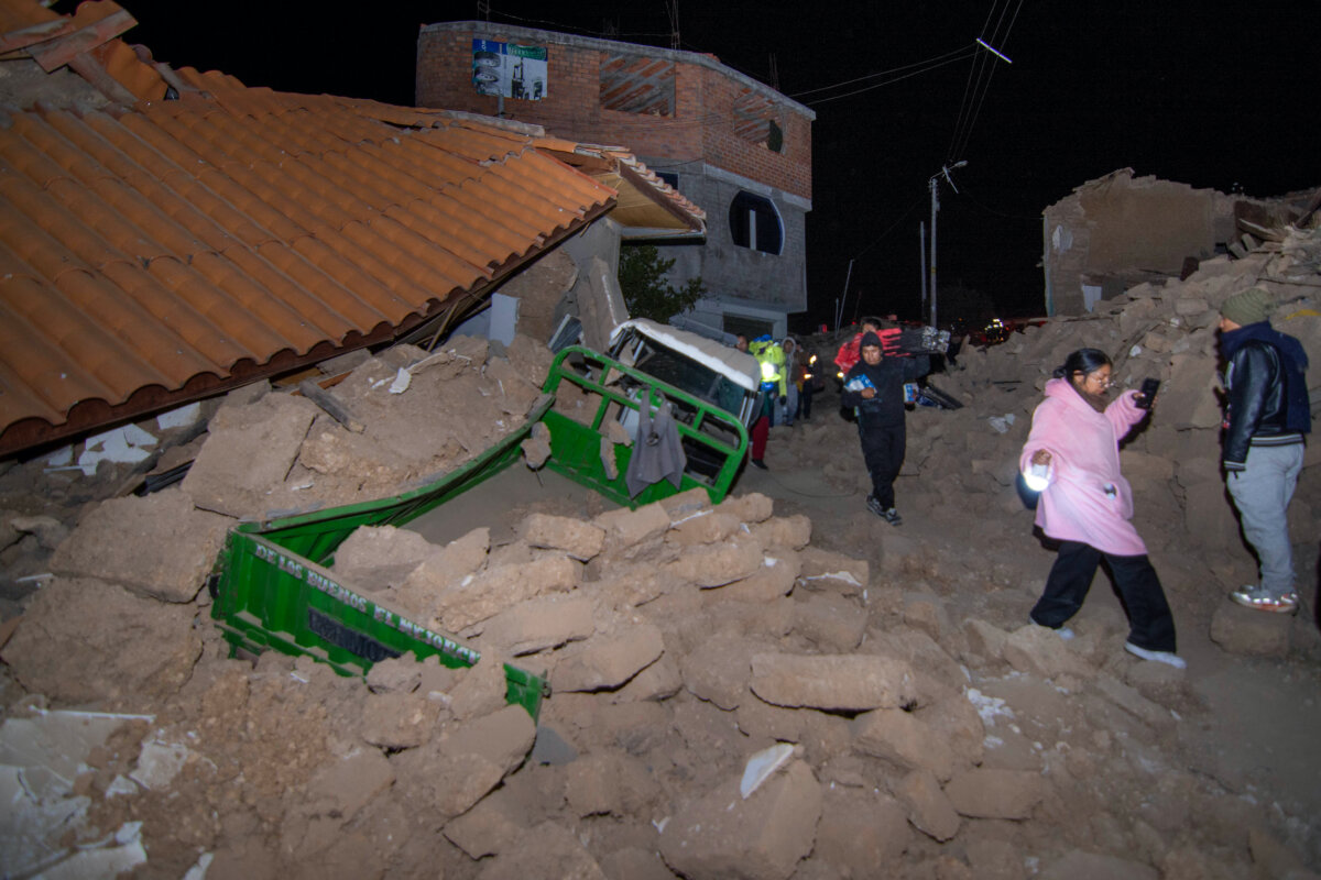 Residents walk amid the debris of homes that collapsed after an earthquake struck Pumpuya, Peru, on July 19, 2026. (Xavier Ninanya/AP Photo)