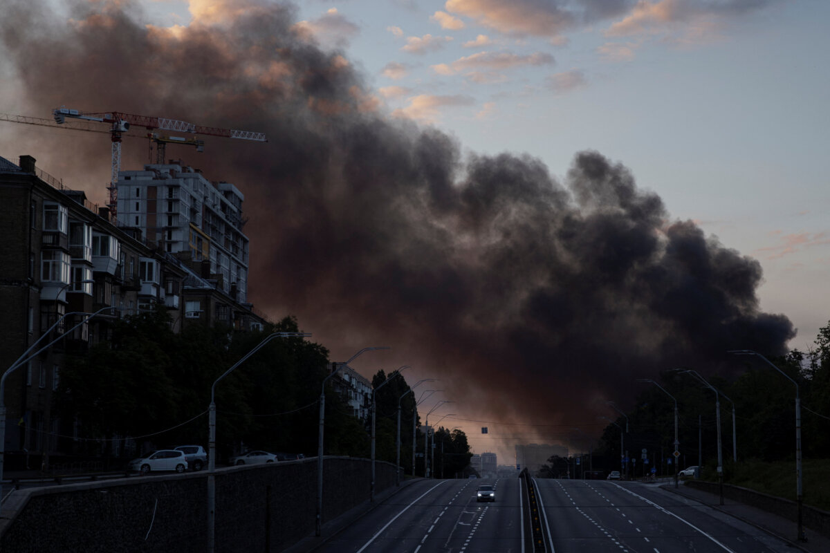 A column of smoke rises over the city as a car drives on a highway following Russian missile strikes, amid Russia’s attack on Ukraine, in Kyiv, Ukraine, July 19, 2026. (Thomas Peter/Reuters)