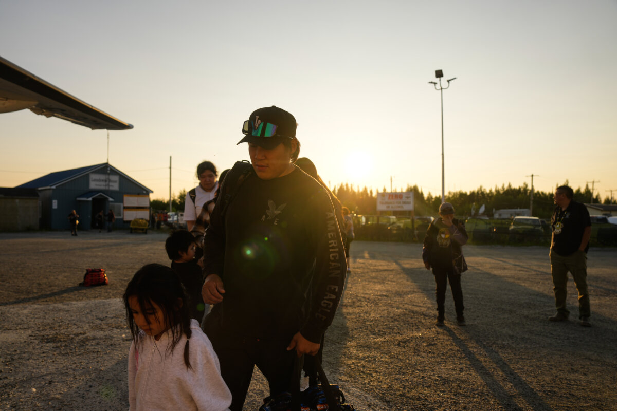 A young family boards a plane as they are evacuated from Neskantaga First Nation, Ont., on July 18, 2026. (The Canadian Press/Chris Young)