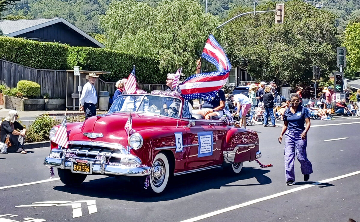 A classic car cruises by at an Independence Day parade in Corte Madera, California, in 2023. (Public Domain)