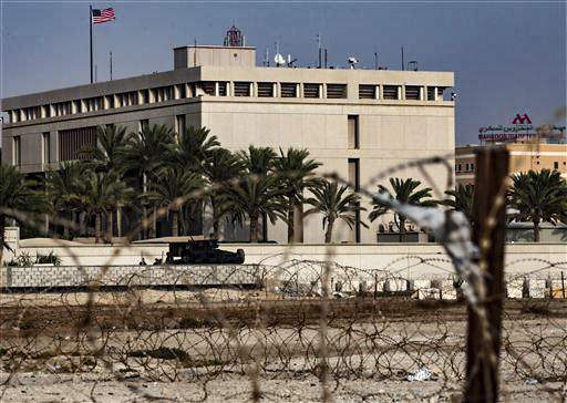 A Bahraini armored personnel vehicle and personnel reinforce U.S. Embassy security just outside of a gate to the building, surrounded in barbed wire, in Manama, Bahrain, on Sunday, Aug. 4, 2013. (AP Photo/Hasan Jamali)