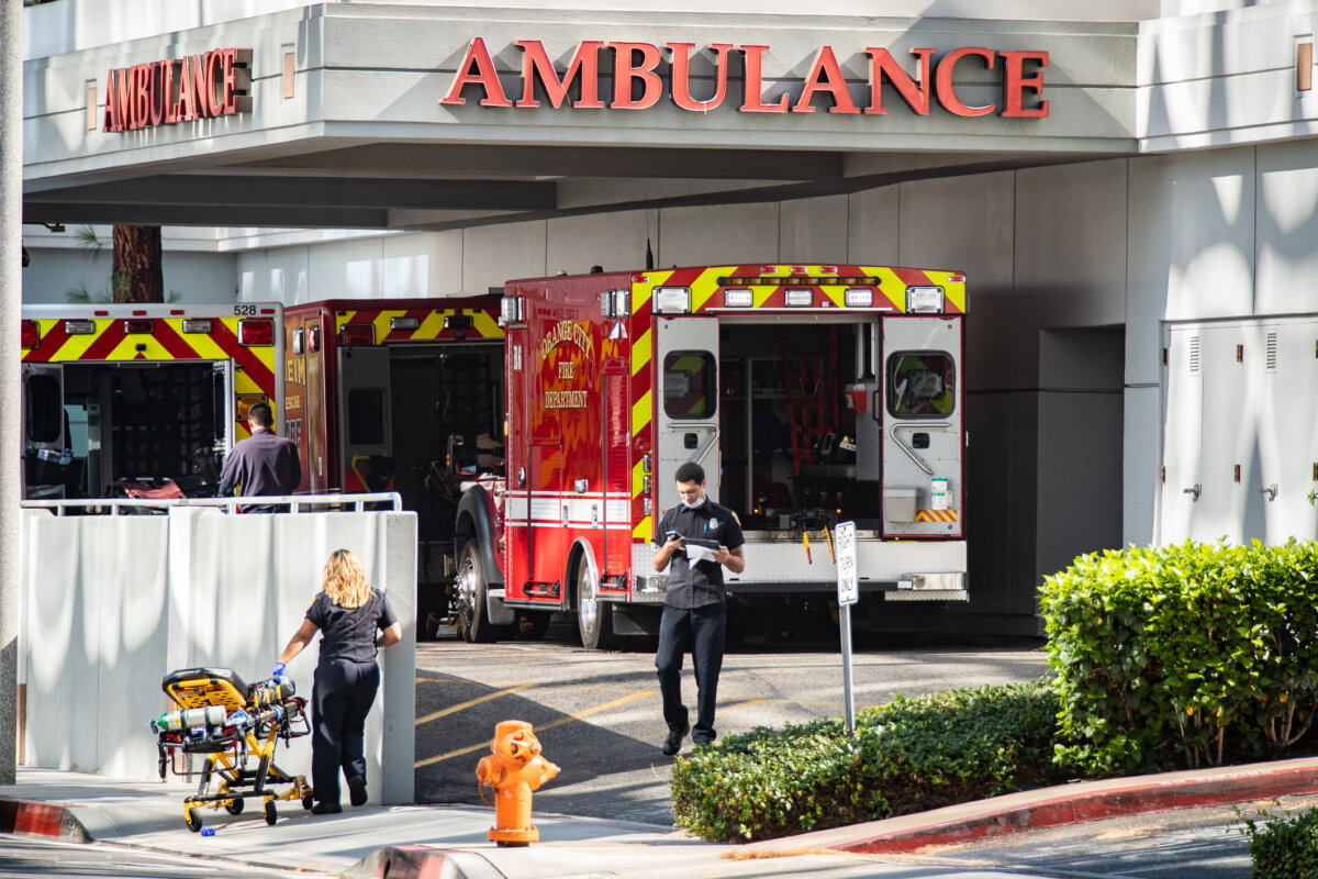Healthcare workers work near an ambulance area of a hospital in Orange, Calif., on Aug. 9, 2021. (John Fredricks/The Epoch Times)