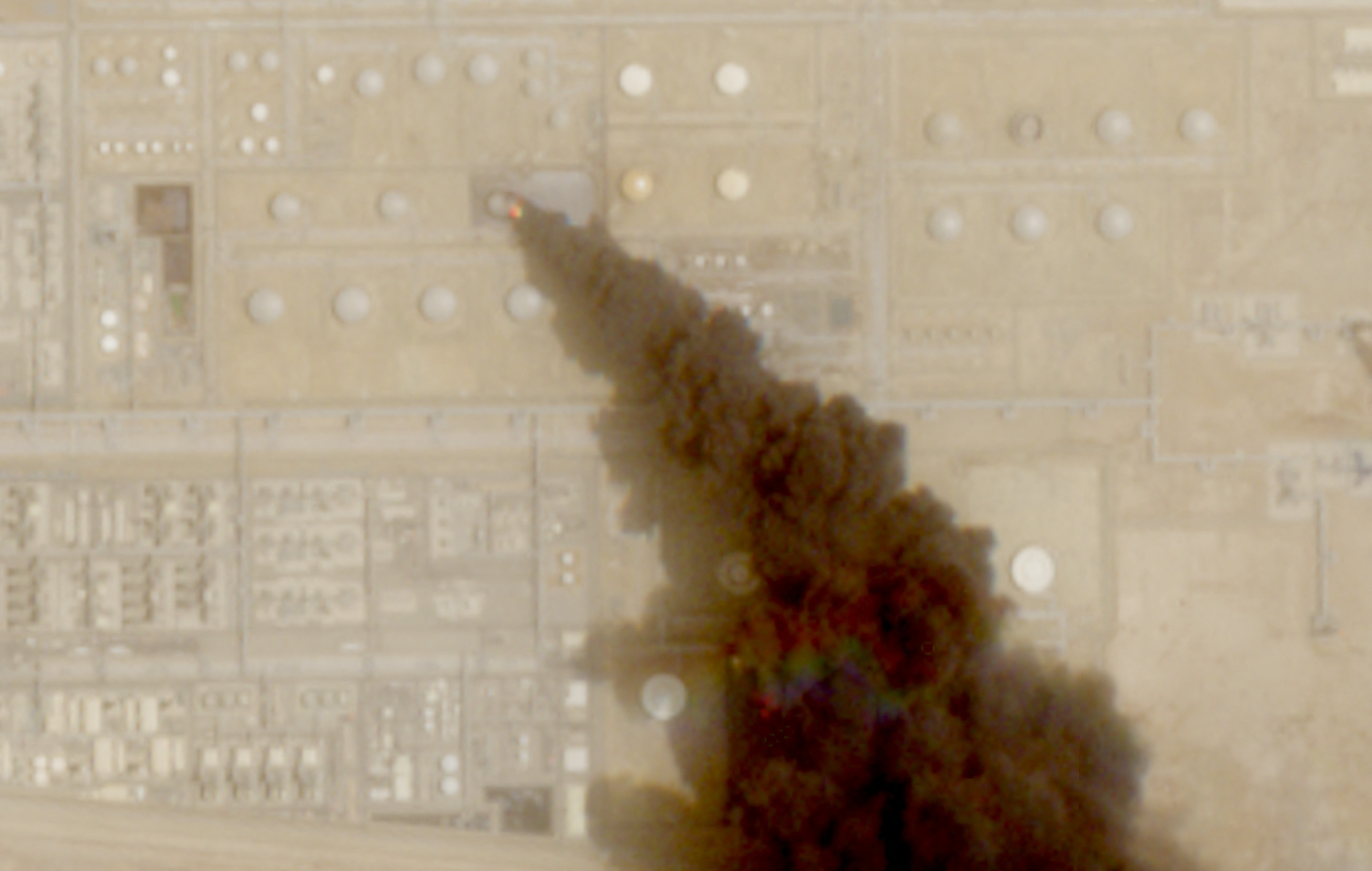 A satellite image shows trail of smoke rising from an oil facility, in Jizan