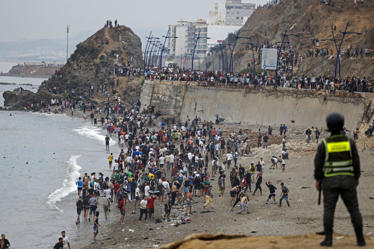 Illegal immigrants gather along the fence at the site of clashes near Fnideq on the Morocco-Spain border, in Fnideq, Morocco, on July 31, 2026. Thousands of immigrants crossed overnight from Morocco into Spain's North African enclave of Ceuta, according to a police source, with 18 people reported dead while attempting to reach the enclave. (Abdel Majid Bziouat/AFP via Getty Images)