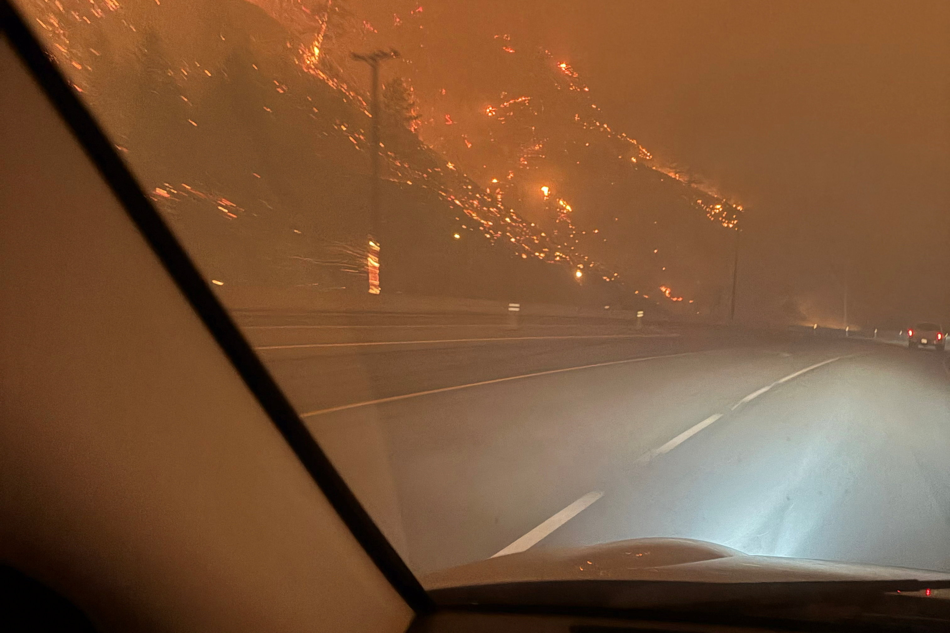 Residents evacuate towards Kelowna after midnight from the Bald Range wildfire along Highway 97 near Summerland