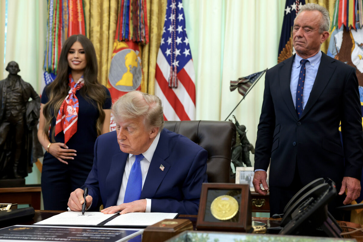 President Donald Trump, accompanied by Health and Human Services Secretary Robert F. Kennedy Jr. (R) and Jayme Leagh Franklin with the The Conservateur (L), signs an executive order calling for childhood vaccine shots to be spaced out into separate visits during an event in the Oval Office of the White House on Aug. 10, 2026. (Anna Moneymaker/Getty Images)