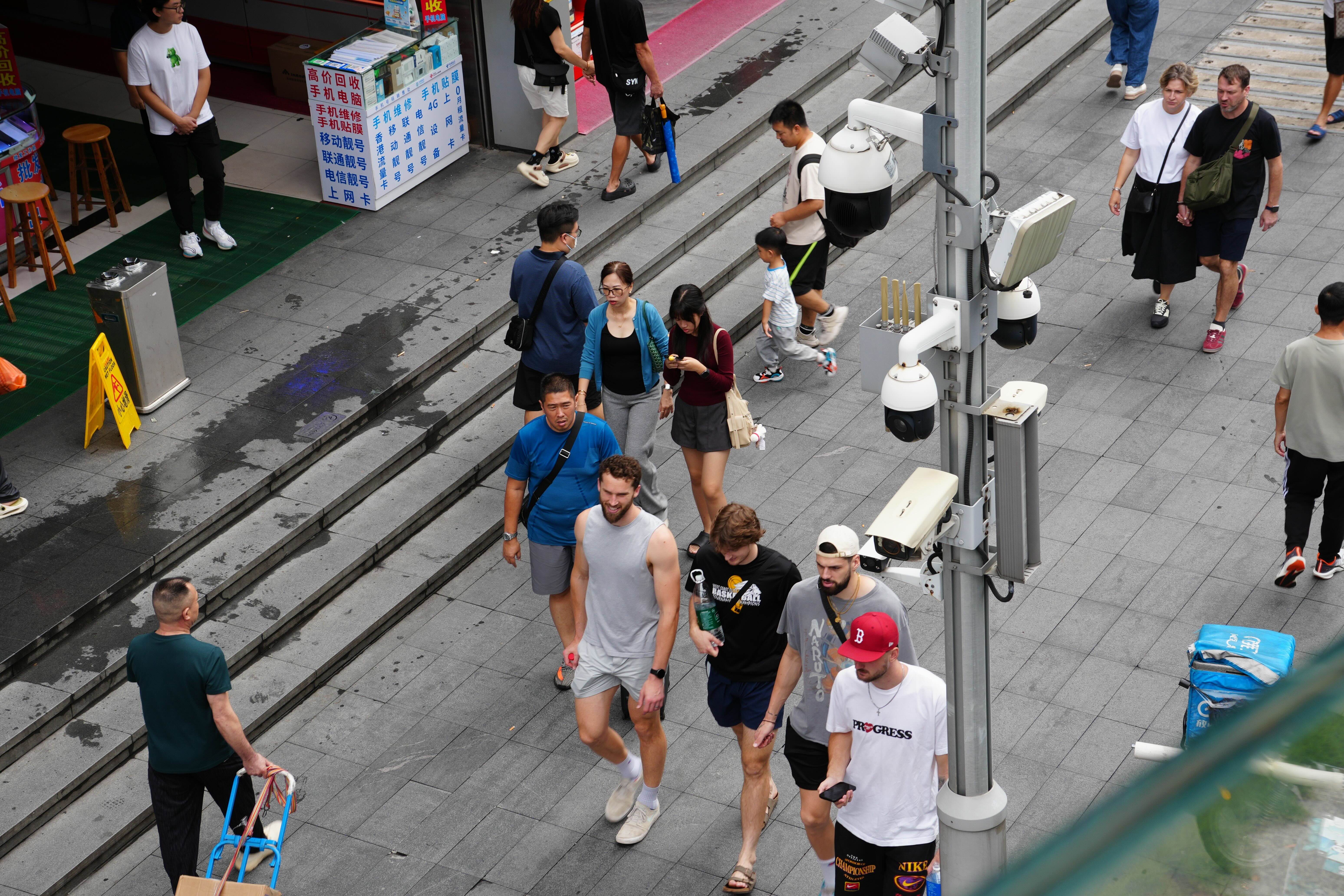 International,Visitors,And,Pedestrians,Walk,Past,Surveillance,Cameras,In,A