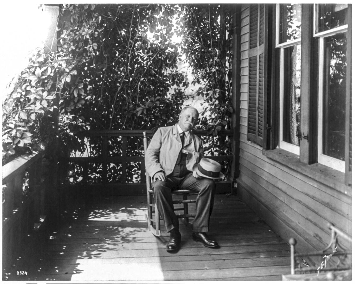 William Dean Howells, circa 1908, full-length portrait, seated on porch. Library of Congress. (Public Domain)