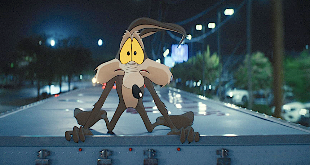 cartoon coyote clings to the top of a truck in Coyote Vs. ACME