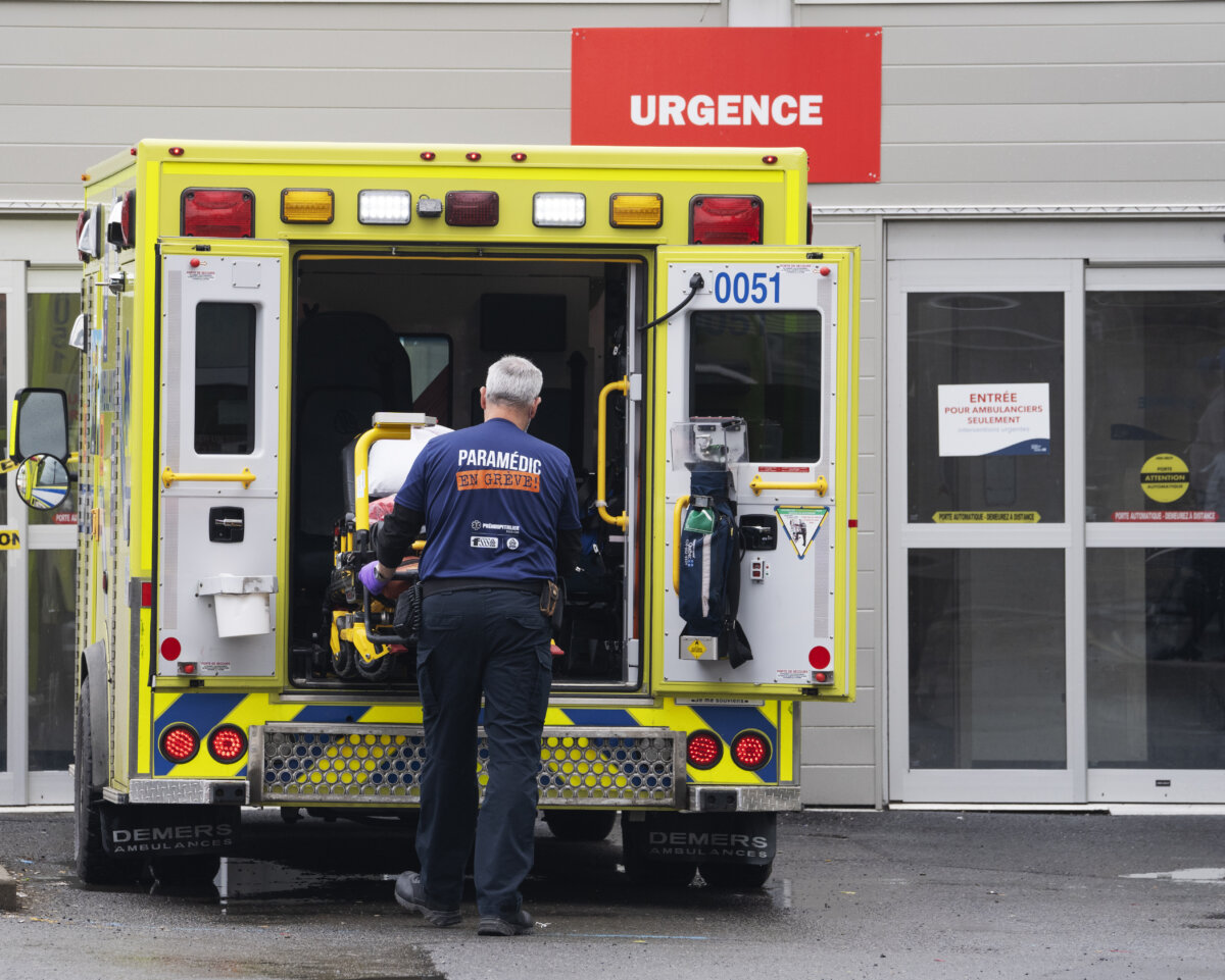 A paramedic loads his stretcher back into the ambulance after bringing a patient to the emergency room at a hospital in Montreal, April 14, 2022. (The Canadian Press/Ryan Remiorz)