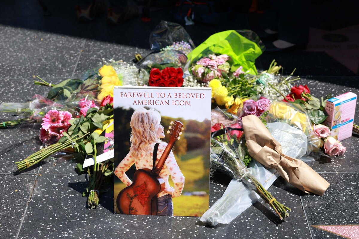 Flowers and a portrait are laid on the late singer-songwriter Dolly Parton’s Hollywood Walk of Fame Star in Los Angeles on Aug. 25, 2026. Parton, the American country music singer who rose from poverty in Tennessee to become a cultural giant with hits like "Jolene" and "9 to 5," has died at 80. (Valerie Macon/Getty Images)