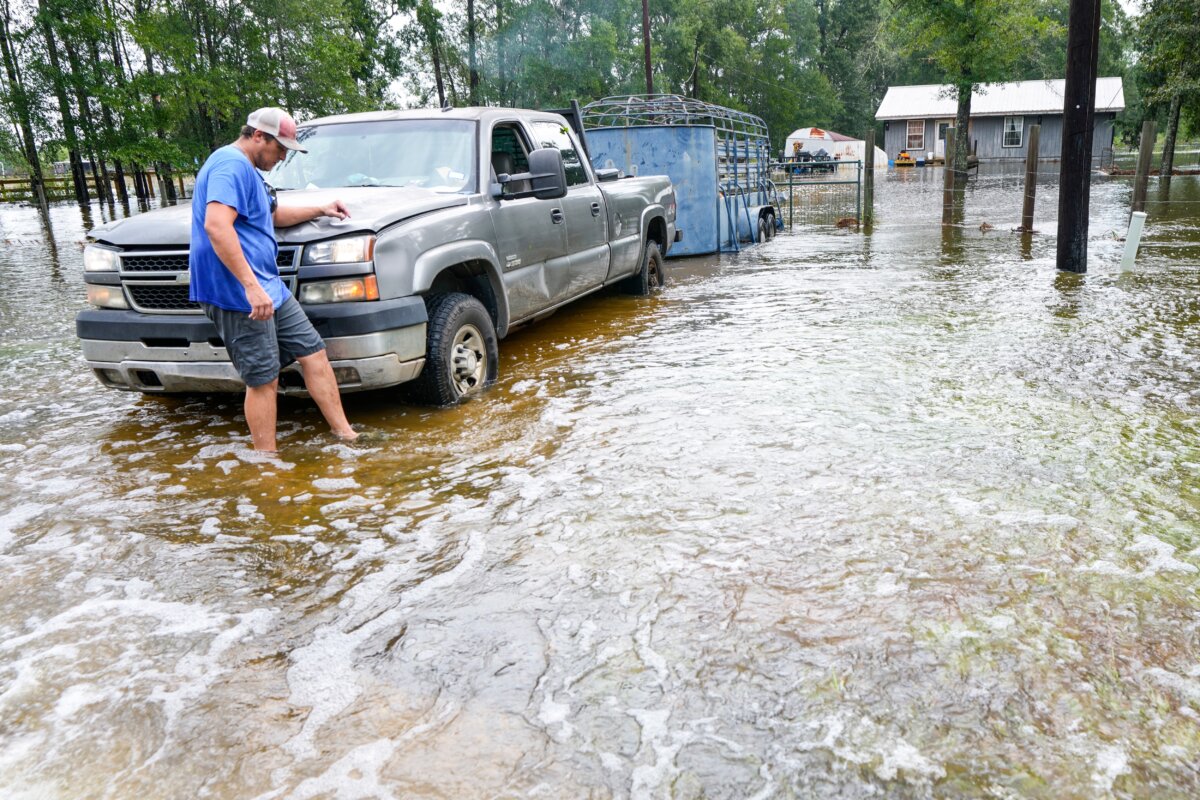 Chase Barfield walks to his truck as he takes belongings and his dogs away from floodwaters around his house in the aftermath of Tropical Storm Edouard near Honey Island, Texas, on Sept. 2, 2026. (Brett Coomer/Houston Chronicle via AP)