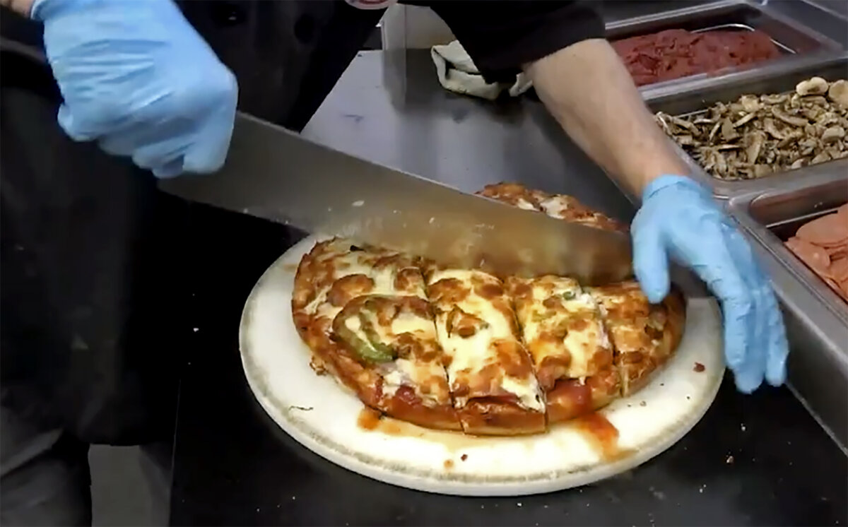 A pizza being cut at Tumblers Pizza in Regina. (The Canadian Press/Jeremy Simes)
