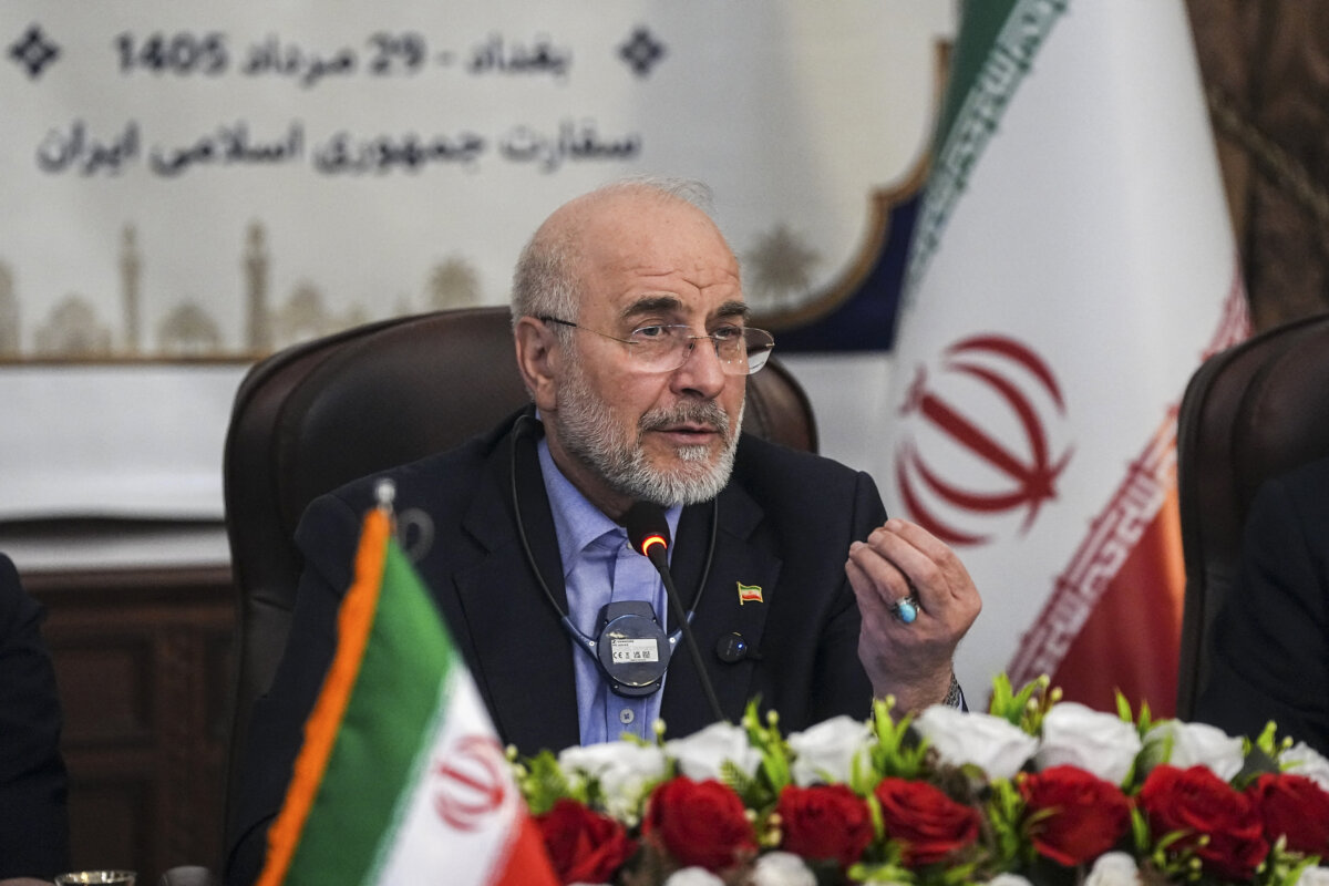 Iranian Parliament Speaker Mohammad Bagher Ghalibaf speaks into a microphone beside Iranian and Iraqi flags during a meeting with business representatives at the Iranian Embassy in Baghdad, Iraq, on Aug. 20, 2026. (Hamed Malekpour/Middle East Images via AFP via Getty Images)
