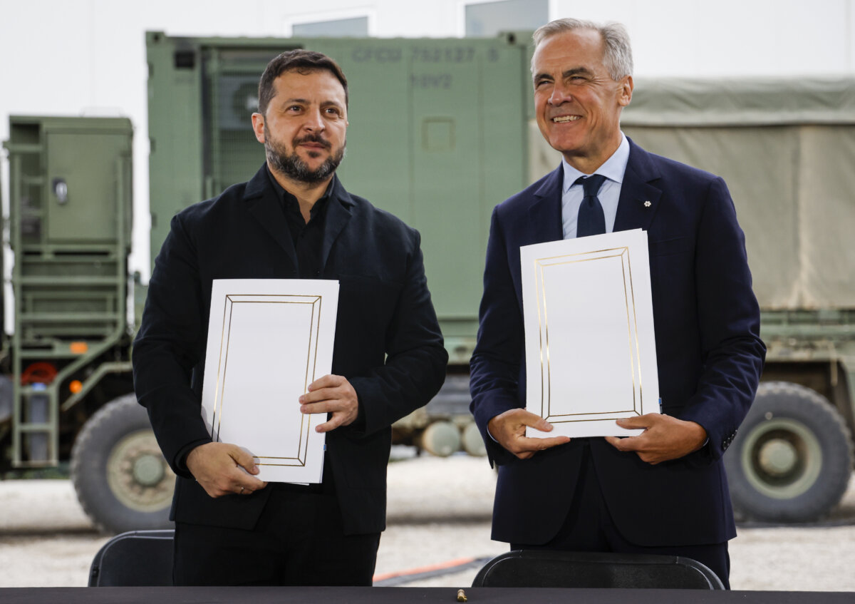 Prime Minister Mark Carney (R) and Volodymyr Zelenskyy, president of Ukraine, sign agreements in Calgary, on Sept. 10, 2026. (The Canadian Press/Jeff McIntosh)