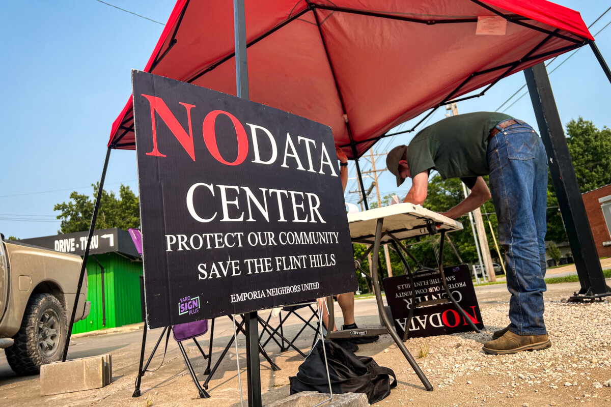 A Kansas man signs petitions provided by Emporia Neighbors United to ban data centers in the area on Aug. 3, 2026. (Jacki Thrapp/The Epoch Times)