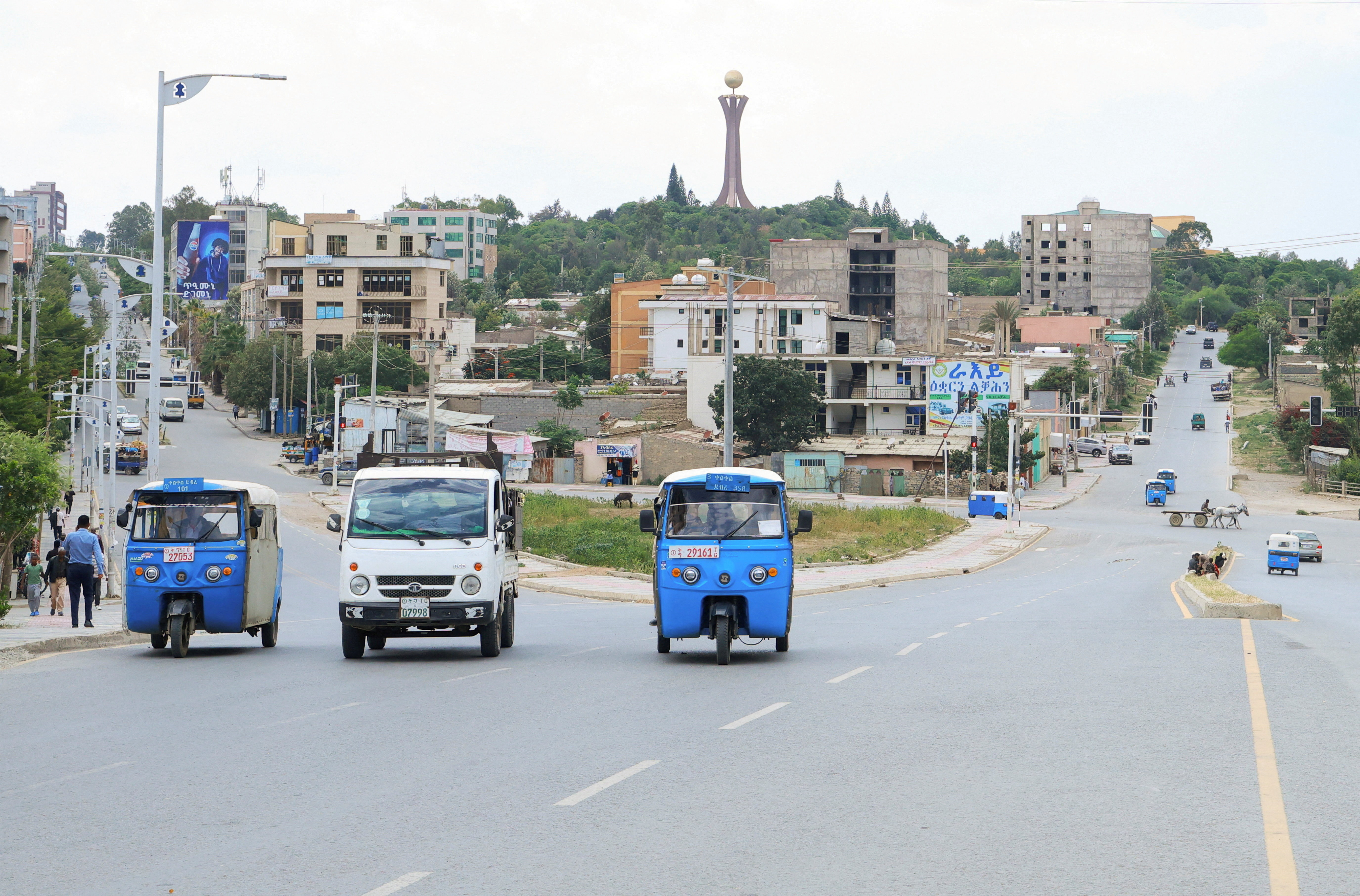Rickshaw taxis and motorists drive along the street near the Tigray Martyrs monument in Mekelle, Tigray Region