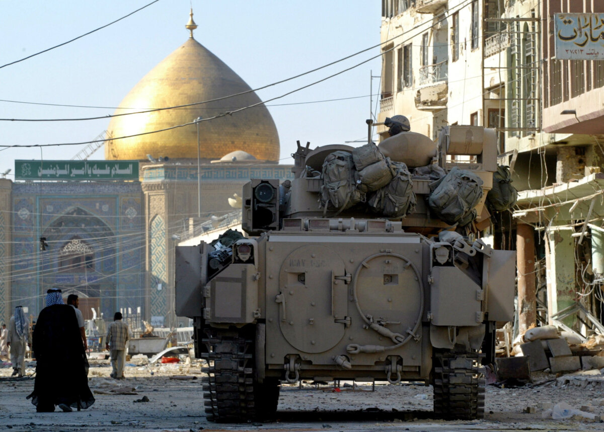 A U.S. Army Bradley armored vehicle of the 1st Cavalry division guards a street leading from the cemetery to Imam Ali shrine, in Najaf, Iraq, on Aug. 27, 2004. (Chris Helgren/Reuters)